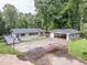 Charming single-story home with a spacious deck and covered carport, surrounded by lush greenery at 8035 Rockbridge Rd, Lithonia, GA 30058
