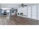 Open-concept living area with laminate flooring, a brick fireplace, and a view into the kitchen at 8035 Rockbridge Rd, Lithonia, GA 30058