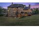 Exterior back view of large brick home with a large, fenced backyard, spiral staircase, and patio area at 1310 Settles Rd, Suwanee, GA 30024