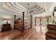 Large bedroom with hardwood floors, a four-poster bed, and elegant window treatments at 1310 Settles Rd, Suwanee, GA 30024