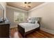 Cozy bedroom with hardwood floors, a queen-sized bed, and a window with natural light at 1310 Settles Rd, Suwanee, GA 30024