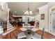Cozy dining area shows staircase, hardwood floors and a stylish chandelier above the glass topped dining table at 1310 Settles Rd, Suwanee, GA 30024