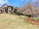 Stone home sits on a well manicured lawn with mature trees and landscaping at 1310 Settles Rd, Suwanee, GA 30024