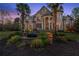 Stately stone home featuring manicured lawn and mature palms at 1310 Settles Rd, Suwanee, GA 30024