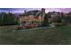 Back of an elegant stone home with manicured lawn and trees at dusk at 1310 Settles Rd, Suwanee, GA 30024