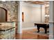 Open game room with a stone archway, billiard table, and coffered ceiling creates an inviting space at 1310 Settles Rd, Suwanee, GA 30024