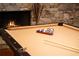 Close-up of a billiard table shows set up in game room, with a stone fireplace in background at 1310 Settles Rd, Suwanee, GA 30024