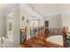 Upstairs hallway showcasing hardwood floors, decorative iron railings, and recessed lighting at 1310 Settles Rd, Suwanee, GA 30024