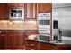 Gourmet kitchen features stainless steel appliances, custom backsplash, granite countertops and rich wood cabinetry at 1310 Settles Rd, Suwanee, GA 30024