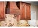 Exquisite kitchen with a custom range hood, decorative tile backsplash, and luxurious wooden cabinets at 1310 Settles Rd, Suwanee, GA 30024