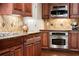 Gourmet kitchen with stainless steel appliances, custom cabinets, and designer tile backsplash at 1310 Settles Rd, Suwanee, GA 30024