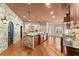 Open kitchen featuring a stone accent wall, wooden cabinets, island with stone base and modern stainless steel appliances at 1310 Settles Rd, Suwanee, GA 30024