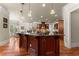 Spacious kitchen with dark wood cabinets, hardwood floors, granite counters and modern stainless steel appliances at 1310 Settles Rd, Suwanee, GA 30024