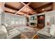 Cozy living room featuring a stone fireplace, hardwood floors, and coffered ceiling at 1310 Settles Rd, Suwanee, GA 30024