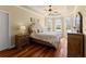 Bedroom with hardwood floors, tray ceiling, large windows, and a tufted headboard at 1310 Settles Rd, Suwanee, GA 30024