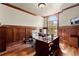Home office with wood paneled walls, hardwood floors, built-in shelving and a large window at 1310 Settles Rd, Suwanee, GA 30024
