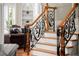 Elegant staircase features decorative iron railings and hardwood steps, enhancing the home's aesthetic appeal at 1310 Settles Rd, Suwanee, GA 30024