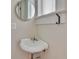 Cozy bathroom with a pedestal sink, round mirror, and a window, offering a minimalist design at 222 Winonna Dr, Decatur, GA 30030