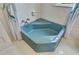 This bathroom features a blue corner tub, tiled floor, and a shower curtain at 222 Winonna Dr, Decatur, GA 30030