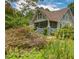 Lovely home with a screened-in porch surrounded by colorful flowers and lush greenery at 222 Winonna Dr, Decatur, GA 30030