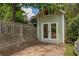 Exterior of a backyard shed with double doors and a concrete foundation with fenced yard at 222 Winonna Dr, Decatur, GA 30030