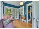 Charming sunroom with blue walls, hanging chair, loveseat, and natural light perfect for relaxation at 222 Winonna Dr, Decatur, GA 30030