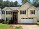 Charming two-story home with a white garage door, brown shutters and light yellow siding at 355 Tambec Nw Trce, Lilburn, GA 30047