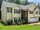 Charming two-story home with a light yellow exterior, brown shutters and a green lawn at 355 Tambec Nw Trce, Lilburn, GA 30047