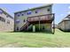 Back exterior view features an expansive yard, wooden deck with stairs, and lush green grass at 4395 Wildbrooke Pkwy, Cumming, GA 30041