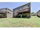 A view of the back exterior features a sprawling lawn and wooden deck with stairs to the yard at 4395 Wildbrooke Pkwy, Cumming, GA 30041