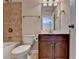 Bathroom with white toilet, shower with brown tile and a dark vanity at 4395 Wildbrooke Pkwy, Cumming, GA 30041