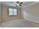 Neutral bedroom with a ceiling fan, plush carpet, a large window offering ample natural light, and crown moulding at 4395 Wildbrooke Pkwy, Cumming, GA 30041