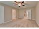 Spacious bedroom featuring carpet flooring, two windows, and three doors at 4395 Wildbrooke Pkwy, Cumming, GA 30041
