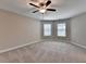 Cozy bedroom featuring carpeted floors, a ceiling fan, and double windows at 4395 Wildbrooke Pkwy, Cumming, GA 30041