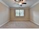 Bedroom featuring plush carpeting, a ceiling fan, and a large window providing plenty of natural light at 4395 Wildbrooke Pkwy, Cumming, GA 30041