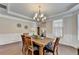 Cozy dining room with wainscoting, an elegant light, and hardwood floors at 4395 Wildbrooke Pkwy, Cumming, GA 30041