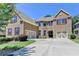 Inviting two-story brick home with a two-car garage and lush green lawn at 4395 Wildbrooke Pkwy, Cumming, GA 30041