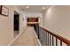 Upstairs hallway featuring wood railing, carpet, and a view of built-in shelves and cabinets at the end of the hall at 4395 Wildbrooke Pkwy, Cumming, GA 30041