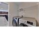 Convenient laundry room includes modern, front load washer and dryer set and wire rack shelving at 4395 Wildbrooke Pkwy, Cumming, GA 30041