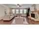 Bright living room featuring a stone fireplace, large windows, and a comfortable seating arrangement at 4395 Wildbrooke Pkwy, Cumming, GA 30041