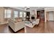 Bright living room with stone fireplace, hardwood floors, with multiple sofas for ample seating at 4395 Wildbrooke Pkwy, Cumming, GA 30041