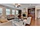 Inviting living room featuring a stone fireplace, hardwood floors, built-in shelving, and abundant natural light at 4395 Wildbrooke Pkwy, Cumming, GA 30041