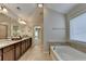 Relaxing bathroom features a soaking tub, tile floors, granite counters, and & sinks at 4395 Wildbrooke Pkwy, Cumming, GA 30041