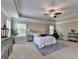 Relaxing bedroom features a tray ceiling, ceiling fan, carpet floors, and neutral color palette at 4395 Wildbrooke Pkwy, Cumming, GA 30041