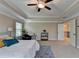 Comfortable bedroom features a ceiling fan, carpet floors, walk-in closet, and access to the en suite at 4395 Wildbrooke Pkwy, Cumming, GA 30041
