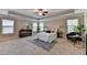 Spacious primary bedroom with tray ceiling, windows and seating area at 4395 Wildbrooke Pkwy, Cumming, GA 30041