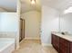 Bright bathroom with tile floors, a granite-topped vanity, soaking tub, and separate glass shower at 1264 Brynhill Ct, Buford, GA 30518