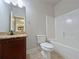 Well-lit bathroom with vanity, toilet, and combination shower-tub at 1264 Brynhill Ct, Buford, GA 30518