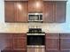 Modern kitchen features stainless steel appliances, granite countertops, and warm-toned cabinetry at 1264 Brynhill Ct, Buford, GA 30518