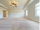 Open main bedroom with neutral walls, carpet flooring, a ceiling fan, and natural light from two windows at 1264 Brynhill Ct, Buford, GA 30518